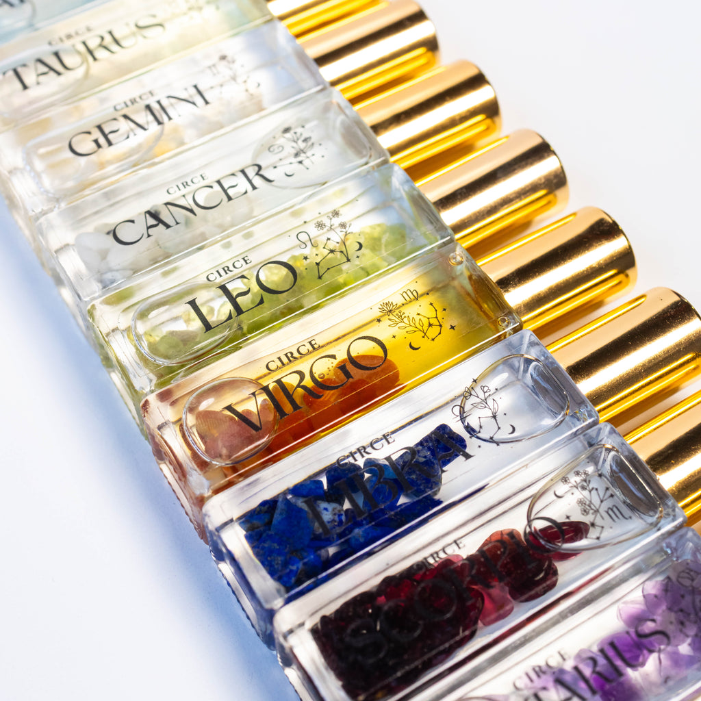 Zodiac Perfume Oil Set by Circe Boutique featuring 12 gemstone-infused zodiac scents in small glass bottles.